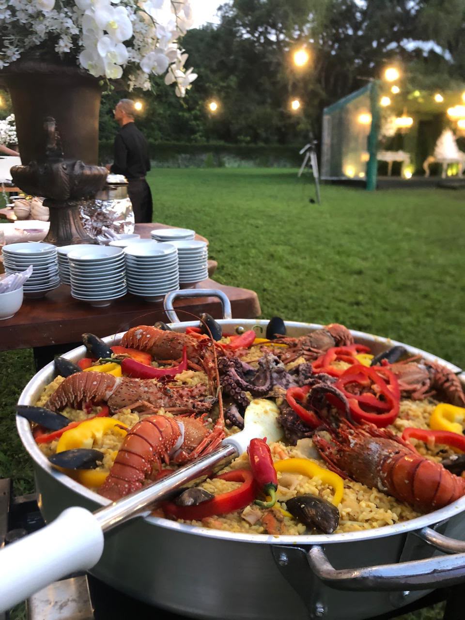 panela grande de paella com lagostas, camarões, polvo, mexilhões e pimentões num buffet ao ar livre em um gram
